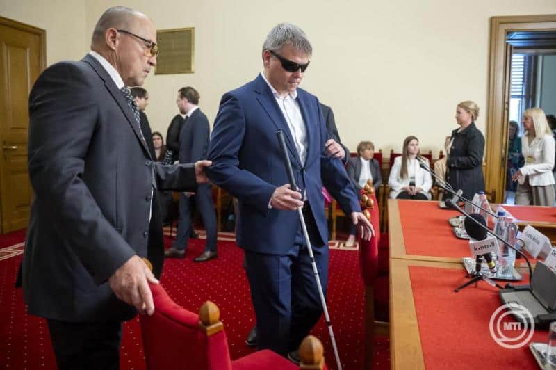 Kátai-Németh Vilmos a gyermekvédelmi ülésen, segítő eszközökkel támogatva.